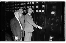 Three men looking at a gage board (1 Negative), undated